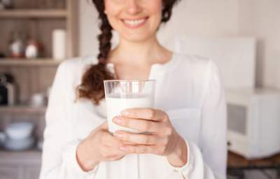 a lady holding a glass of milk